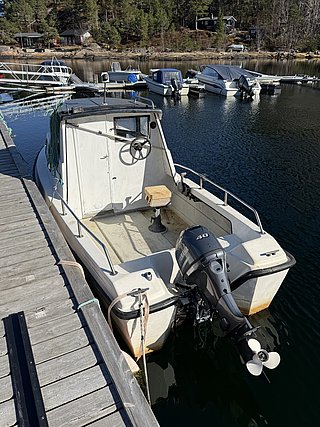 Ein einsames Fischerboot liegt am Steg in einer idyllischen Bucht in Nord-Norwegen. Perfekt für Angelabenteuer in unberührter Natur und ruhigen Gewässern. Ideal für begeisterte Angler, die Entspannung und reiche Fanggründe suchen.