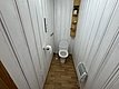 Gemütliches Badezimmer in Hitra, Norwegen. Holzvertäfelung, modernes WC, platzsparende Regale, Heizung für Komfort. Ideal für Angelurlauber nach einem erlebnisreichen Tag. Skandinavische Schlichtheit vereint Funktionalität und Design.