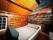 Gemütliches Holzinterieur in norwegischem Ferienhaus auf Hitra. Rustikales Schlafzimmer mit Bett und kunstvoll bemalter Wand. Ideal für Angelurlaub und Erholung in der Natur.