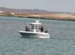 Ein weißes Angelboot auf türkisblauem Wasser vor der Küste von Sao Vicente, Kapverden. Perfekte Bedingungen für Meeresangeln und Erkundungen in dieser idyllischen Umgebung. Abenteuer und Entspannung mitten im Atlantik.