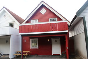 Rotes Holzhaus mit Balkon in Südwest-Norwegen. Traditionelle Architektur, idealer Ausgangspunkt für Angelreisen. Ruhige Umgebung, perfekte Kombination aus Abenteuer und Entspannung. Skandinavisches Flair für unvergessliche Urlaubserlebnisse.