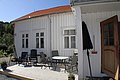 Gemütliche Holzterrasse mit Gartenmöbeln an traditionellem weißen Haus in Hitra, Norwegen. Sonnige Umgebung ideal zum Entspannen während eines Angelurlaubs. Perfekte Basis für Anglerabenteuer in der malerischen Region.