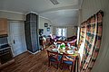 Gemütliches Wohnzimmer in Nord-Norwegen, Holzmöbel, Esstisch, gemütliche Couch, helle Fenster, rustikale Holzoptik, ideal für Angelurlaube. Perfekt für Entspannung nach erlebnisreichen Angelausflügen.