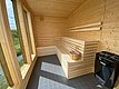 Helle Holzsauna in Nordland, Norwegen, mit modernem Ofen und großen Fenstern für weiten Ausblick. Perfekter Entspannungsort nach einem erfolgreichen Angelausflug. Ideal für Erholung in skandinavischem Ambiente.
