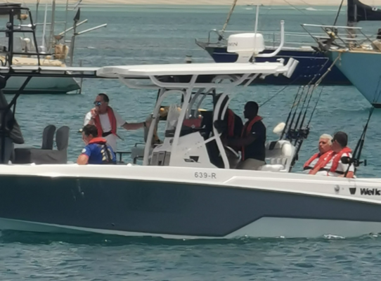 Motorboot vor Sao-Vicente, Kapverden: Fünf Personen in Schwimmwesten genießen das Angelerlebnis auf dem Meer. Ideal für Angelreisen, Abenteuer und Entspannung in malerischer Küstenlandschaft, umgeben von blauen Wellen.