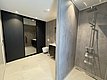 Modernes Badezimmer in Hitra, Norwegen: offene Dusche, große Spiegelfront, stilvolle graue Wände, helle Fliesen, dezente Beleuchtung. Perfekt für Angelreisende, die nach einem erfolgreichen Tag Erholung und Komfort suchen.