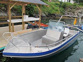 Metallisches Angelboot mit Steuerung, festgemacht an einem Holzsteg in Südwest-Norwegen. Ideal für Angelabenteuer in Fjorden. Ruhiges Wasser und grüne Küste im Hintergrund sorgen für entspannte Stimmung. Perfekt für Anglerreisen.