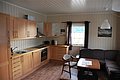 Gemütliche Ferienhausküche in Nordland, Norwegen, mit moderner Einbauküche, Esstisch und Sofa. Perfekt für Angelabenteuer und Erholung in idyllischer Umgebung. Ideal für Angelreisen und Naturliebhaber.