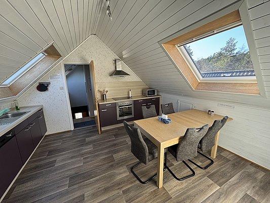 Gemütliche Küche in Hitra, Norwegen, mit Holzoptik, Dachfenstern und modernen Annehmlichkeiten. Perfekt für Angelurlauber. Entdecke die fischreichen Gewässer in stilvollem Komfort. Ideal zum Entspannen nach dem Fischen. Petri Heil in Skandinavien!