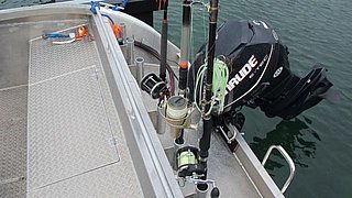 Aluminium-Angelboot, ausgestattet mit Rutenhaltern und einem leistungsstarken Außenbordmotor, auf ruhigem Wasser in Nord-Norwegen. Ideal für Angelreisen und Meeresangeltouren, kombiniert Abenteuer mit Komfort und hoher Fangchance.