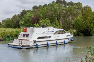 Hausboot auf dem River Shannon, Irland, umgeben von üppigem Grün. Perfekt für entspannten Angelurlaub oder Flusskreuzfahrt. Genießen Sie die Ruhe der Natur und das Abenteuer auf dem Wasser.