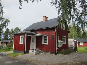 Rotes Holzhaus in Hälsingland, Schweden, umgeben von grünen Bäumen. Skandinavisches Design in ländlicher Idylle, ideal für Erholung und Naturerlebnis. Perfekter Ausgangspunkt für Angelreisen und Outdoor-Abenteuer.