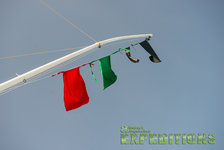 Ein Bootsmast mit bunten Fahnen weht unter klarem Himmel auf den Malediven. Ideal für Angelreisen und maritime Abenteuer. Perfekte Bedingungen für leidenschaftliche Angler.
