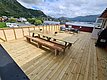 Geräumige Terrasse mit hölzernen Sitzmöbeln, Grill und atemberaubendem Blick auf Fjord und Berge in Südwest-Norwegen. Perfekt für entspannte Angelurlaube und Naturgenuss. Ideal für Gruppen und Familien.